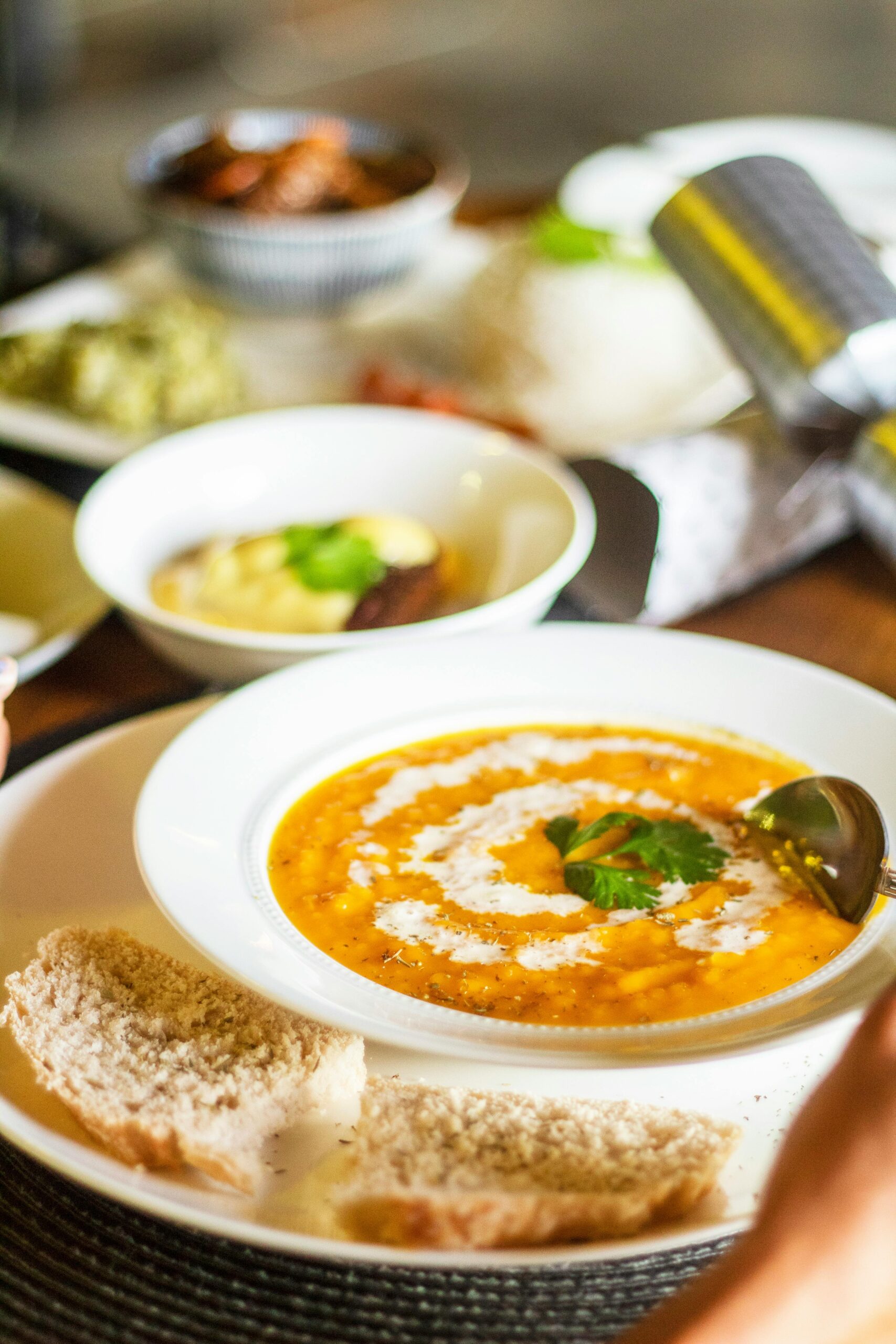 Warm and inviting bowl of creamy tomato soup garnished with cilantro, served with fresh bread.